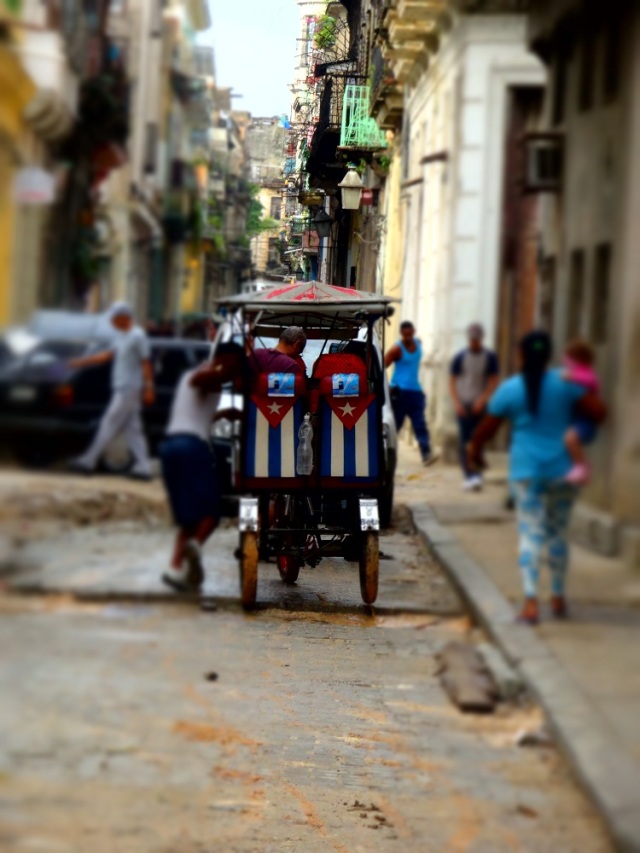 A bici-taxi navigates the rubbles strewn streets (due to road construction, not bombs)